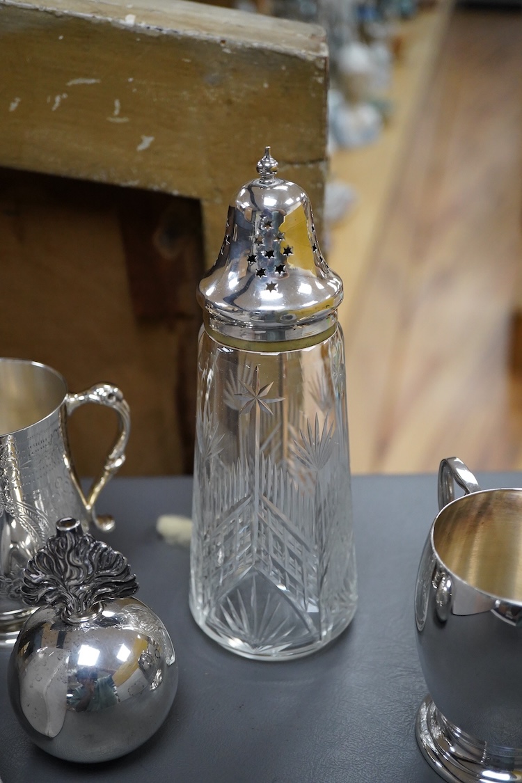 A silver plated etched cup, silver plated cup, a silver plated candlestick, two silver napkin rings, a cut glass sugar shaker and a silver paperweight & eight other items.